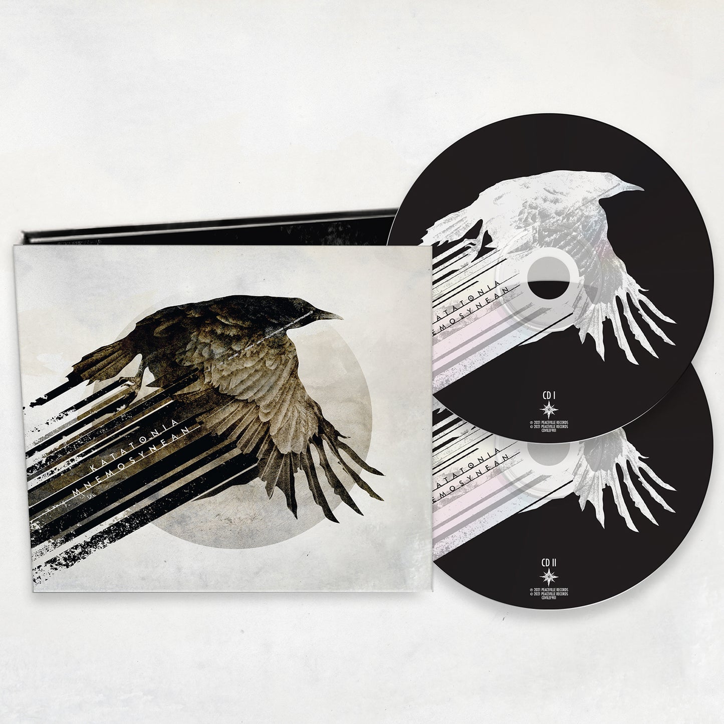 A deluxe Katatonia mediabook CD set featuring crow-in-flight cover art with brush stroke accents. Includes two CDs with matching artwork—ideal for fans of dark prog and Katatonia rarities—partially visible beside the open case.
