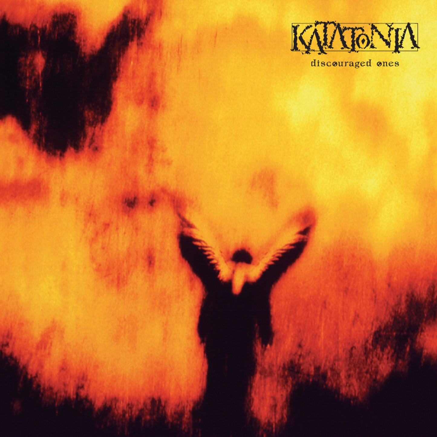 A dark, winged figure stands before a fiery orange-yellow backdrop as Katatonia’s “Discouraged Ones” title appears above. Available now on limited edition orange marble vinyl.