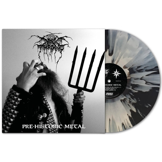A black and white splatter vinyl by Darkthrone is partially pulled from its sleeve. The album cover features a person in a studded jacket with a pitchfork, making a hand gesture, with "Pre-Historic Metal" and "Darkthrone" written below.