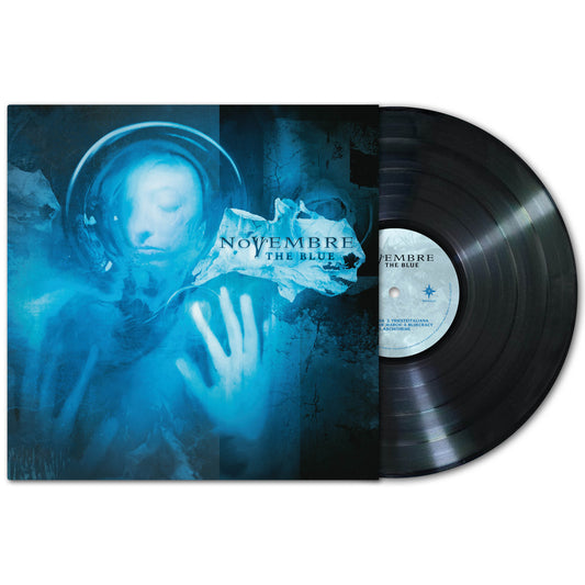 A Novembre vinyl is partially pulled from its blue-toned cover, which shows an ethereal figure with a raised hand and "Novembre The Blue" text at the center—a striking Italian death/doom album by the band Novembre.