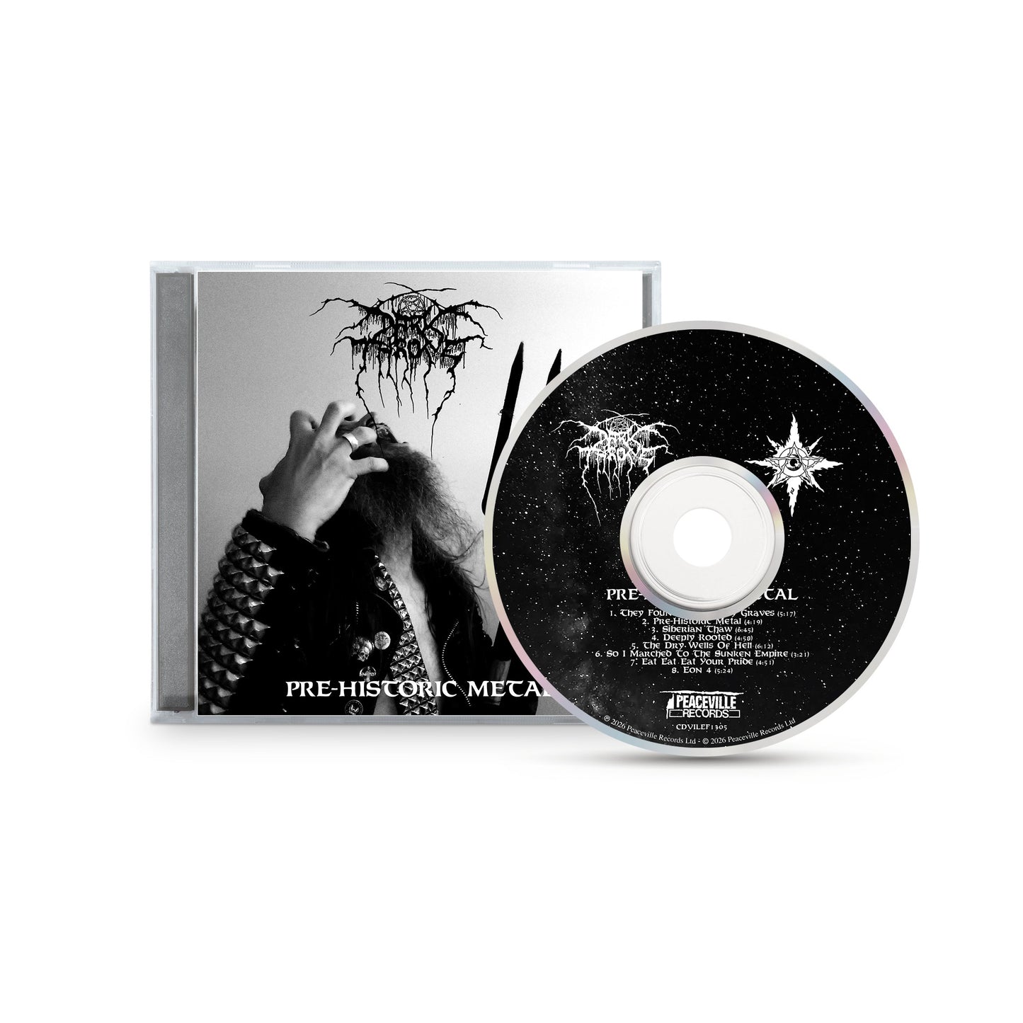 CD case and disc for "Pre-Historic Metal" by Darkthrone, featuring a black-and-white photo of a long-haired figure in metal-studded attire on the cover. The CD displays a starry night with the white Darkthrone logo, reflecting primitive metal roots.