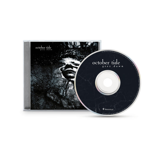 CD and case of "Grey Dawn" by October Tide, featuring a grayscale cracked-texture face with closed eyes on the cover. The black disc has white text and matching crack patterns. Brand: October Tide.